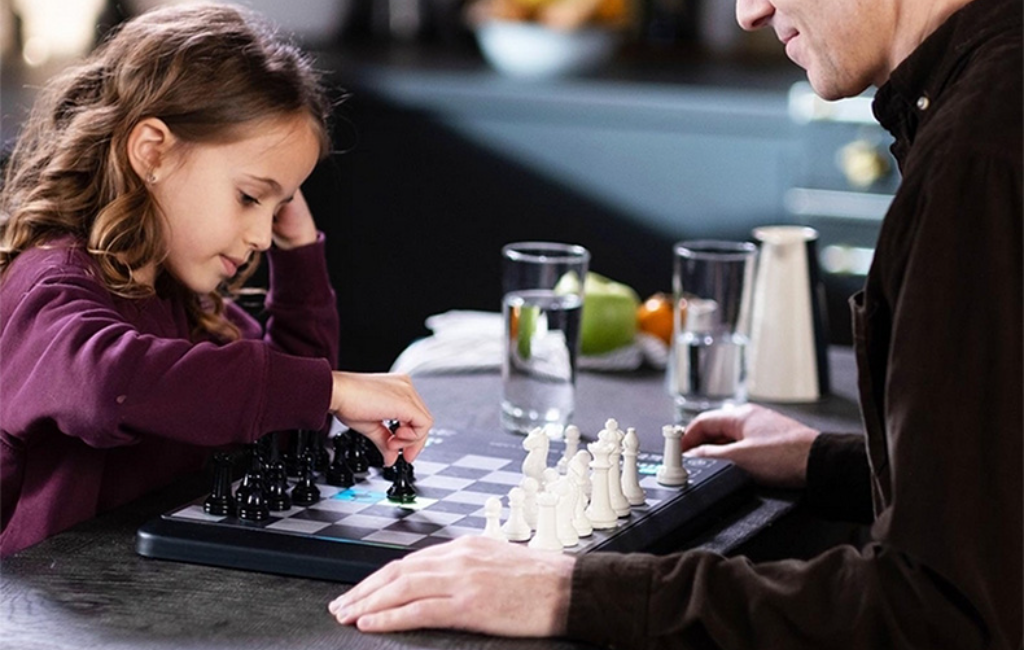 a girl playing chess using chessup electronic chess board