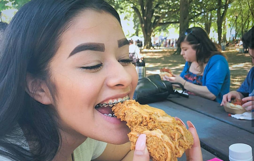 a girl eating atlas monroe chicken