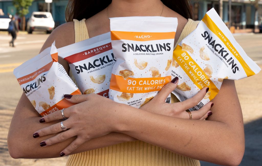 girl holding snacklins plant crisps