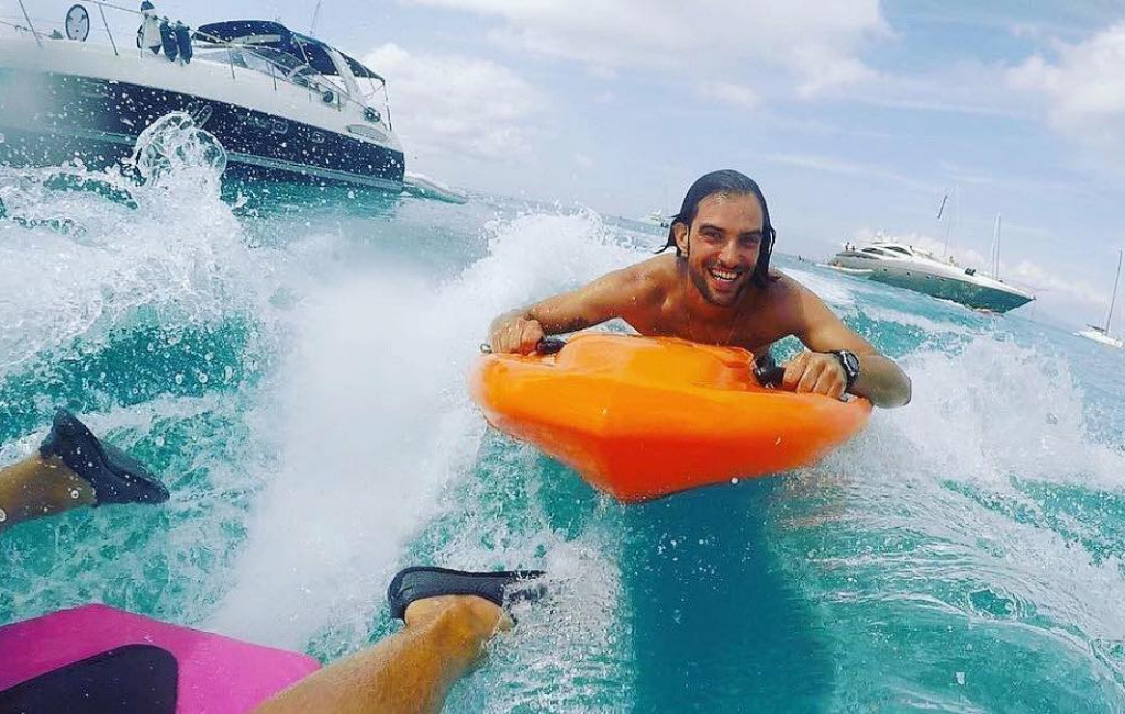 man surfing among boats