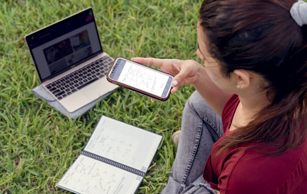 woman sitting on grass and taking photo